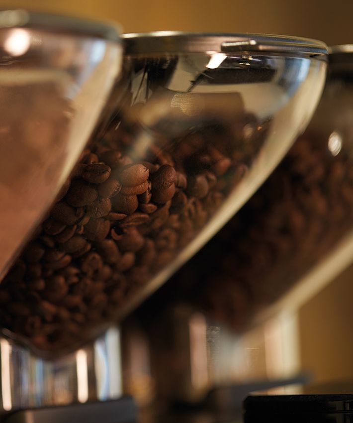 Contenitori trasparenti con chicchi di caffè nelle macchine professionali